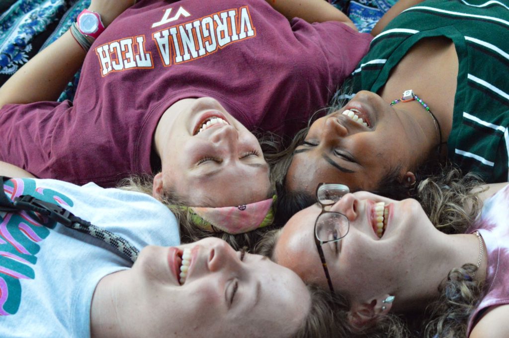 Campers laying in a circle with their heads together